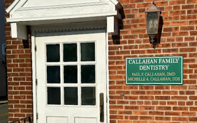 The image shows a sign on a brick building with a white door frame, indicating Callahan Family Dentistry and a plaque below it stating Parker A. Callahan, DMD.